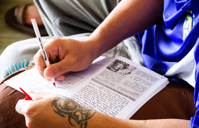 A former homeless man using an ACN-aided catechesis book for the Belém Mission